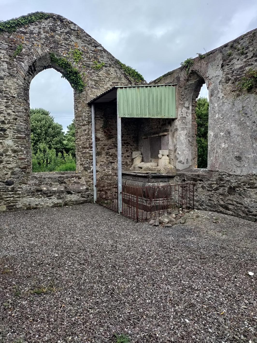 An old stone building with a stone wall and a stone arch Description automatically generated with medium confidence